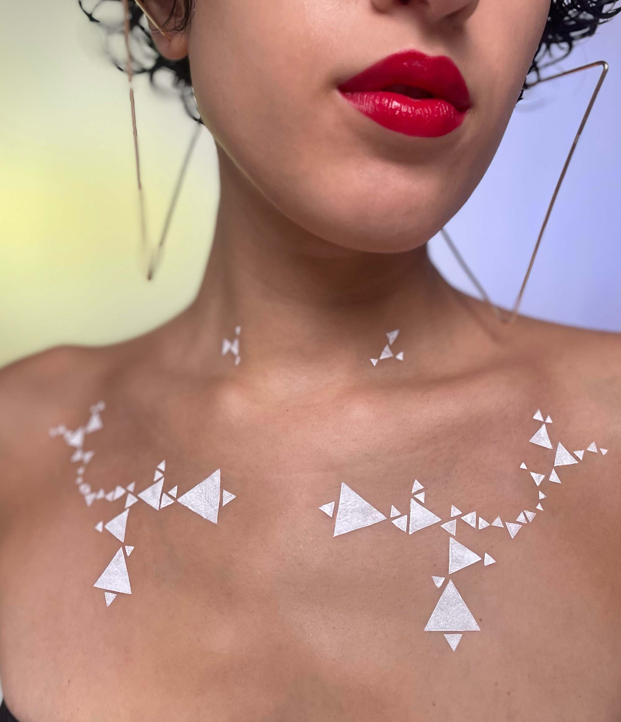 Model with mediium skin tone showcasing deepdive colorpot in Matilija with geometric triangle pattern across their chest.
