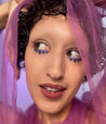 Model with medium skin tone wearing Colorwand in costas under her eyes in triangle pattern.