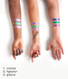 Three forearms, ranging from dark to light skintone, wearing the 3 different colorwand colors.