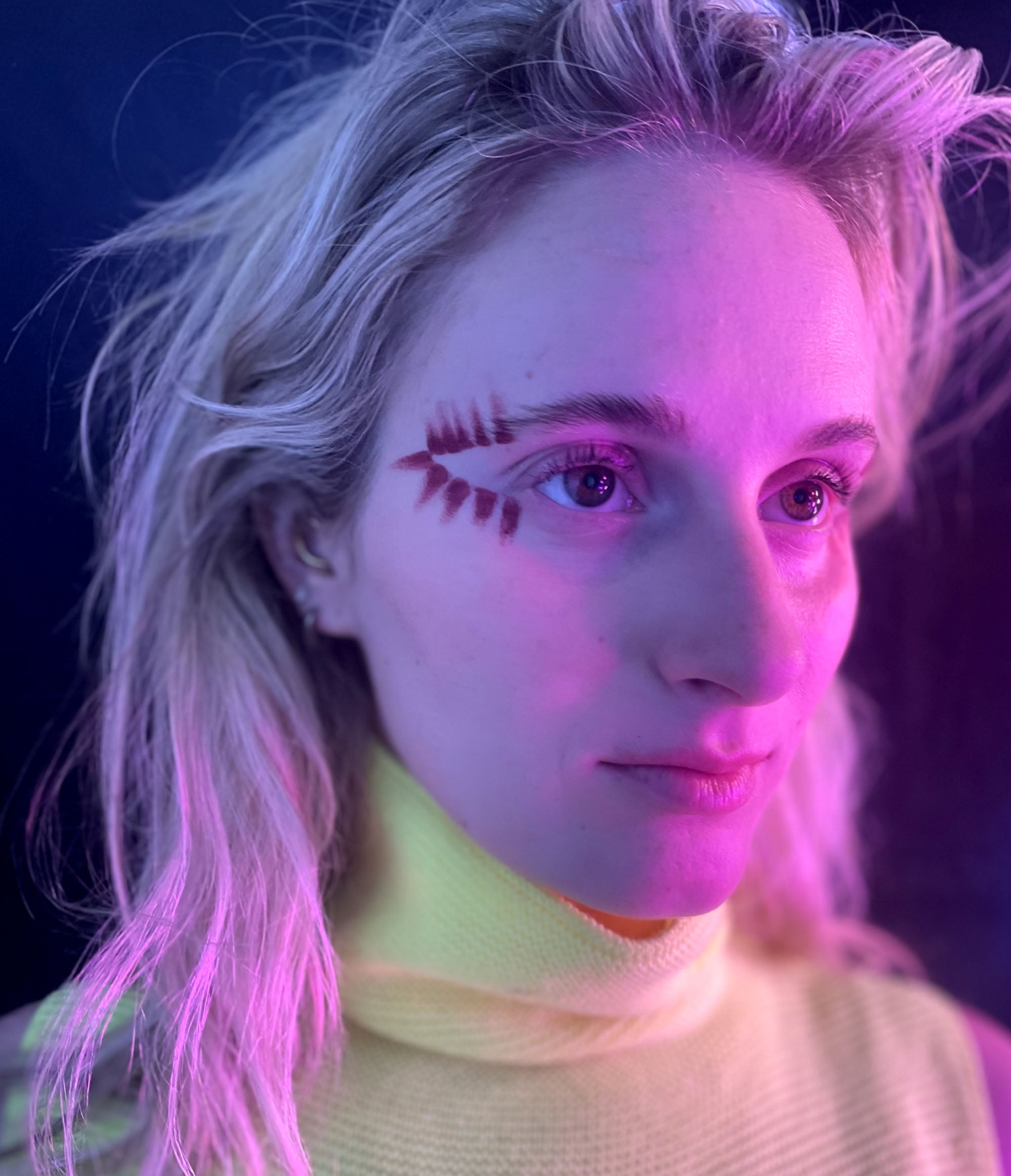 Side view of a model wearing Aeonium in a design along the outer corners of their eye