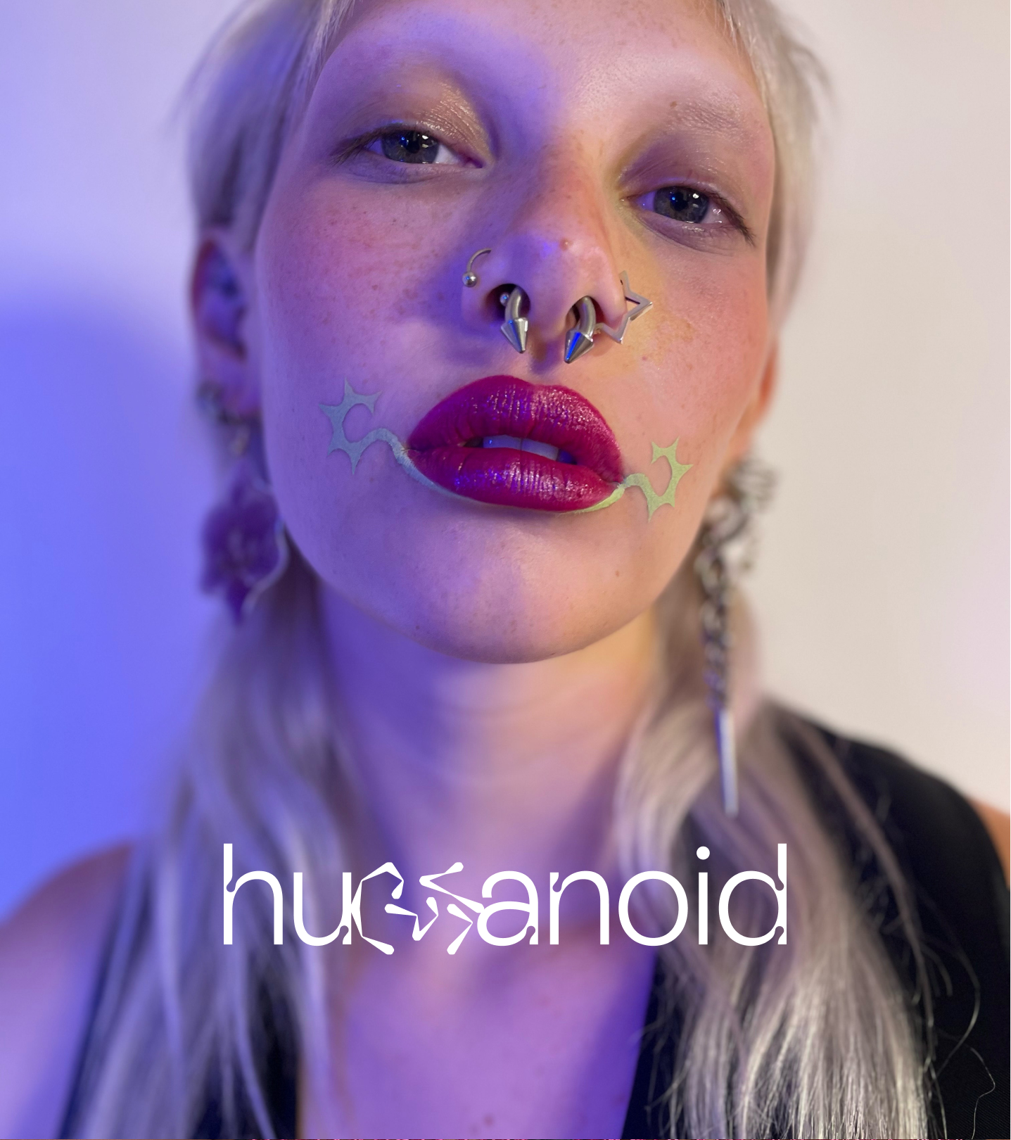 Model wearing Humanoid deepdive colorpot in Sagebrush under bottom lip with starburst at corners of their mouth.