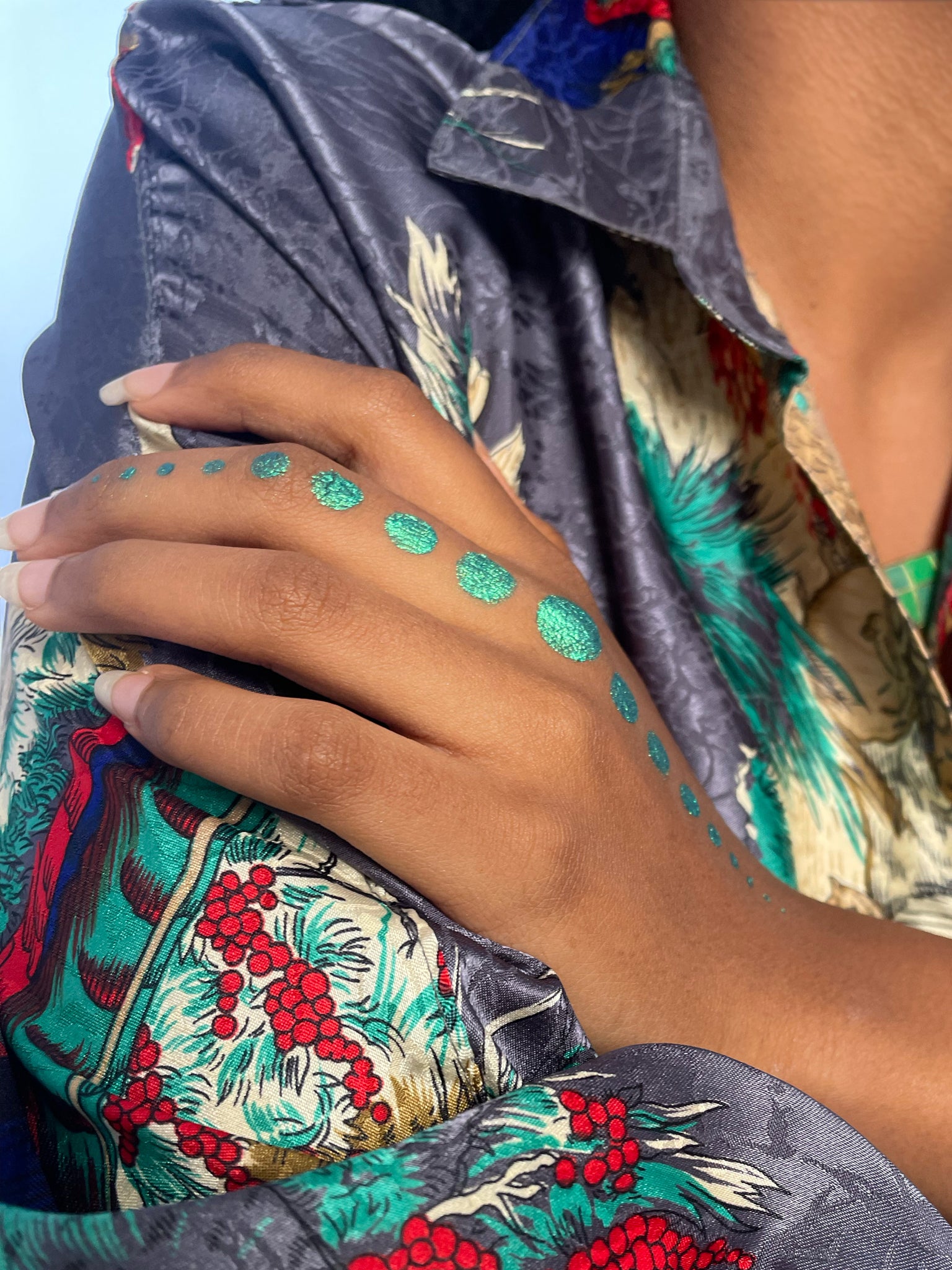 Model with dark skin tone wearing colorwand figeater in big dots on the top of their hand from the middle finger to their wrist.