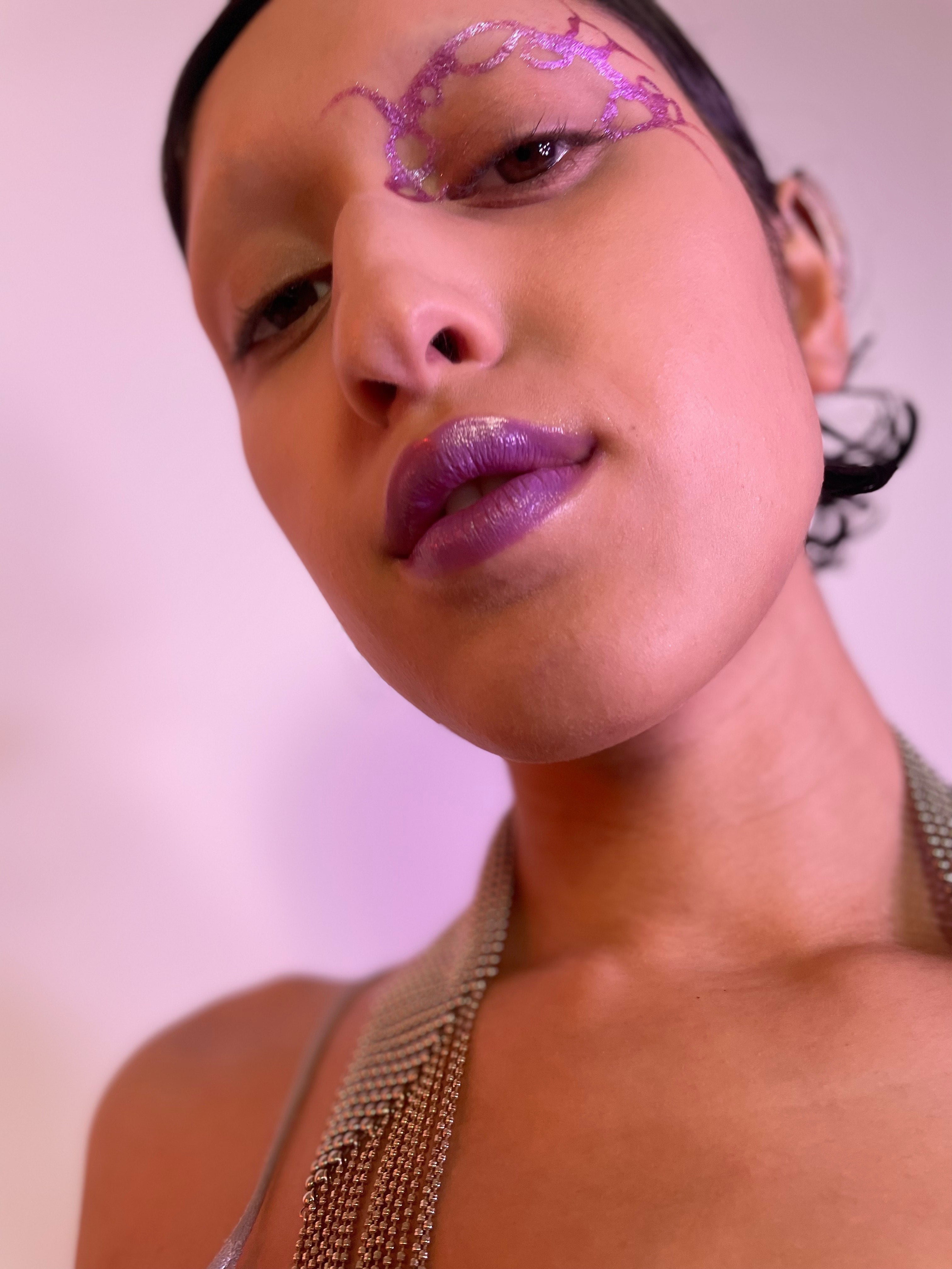 Model with medium tone skin wearing Colorwand in glabra along their left inner nose and brows and on their lips.