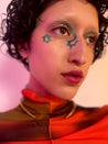 Model with medium skin tone wearing figeater in an arch under their brow with a star on the inner and outer corners of their eyes.