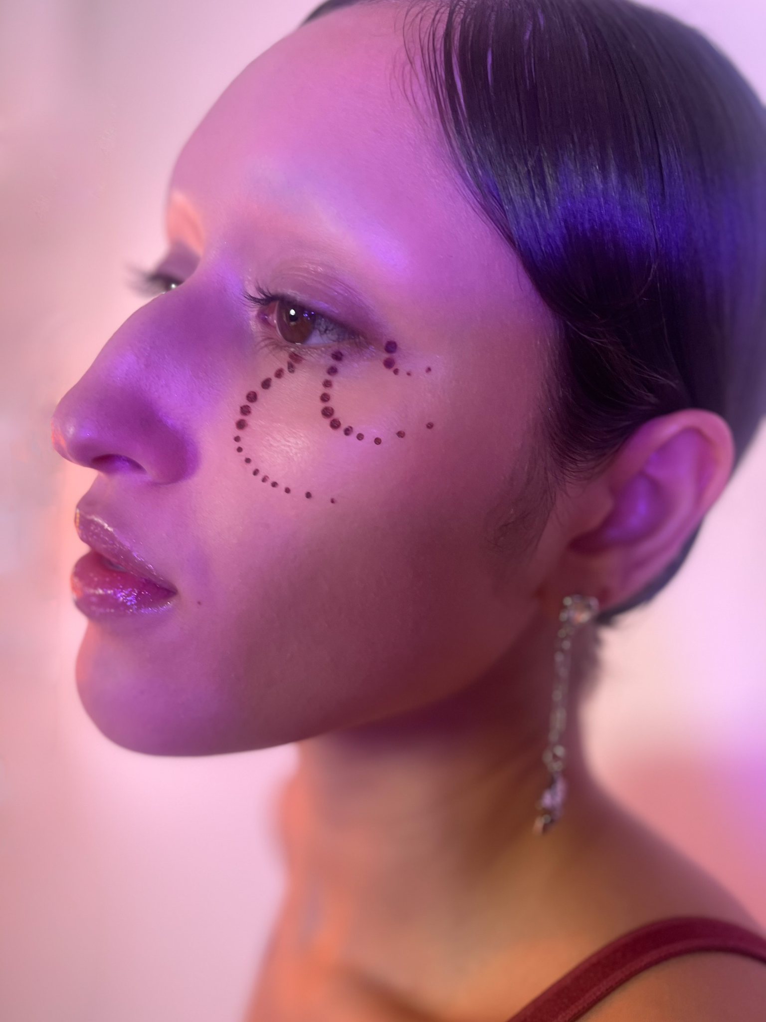 Side view of a Model with a medium skin tone wearing Aeonium in a dot pattern under their eye.