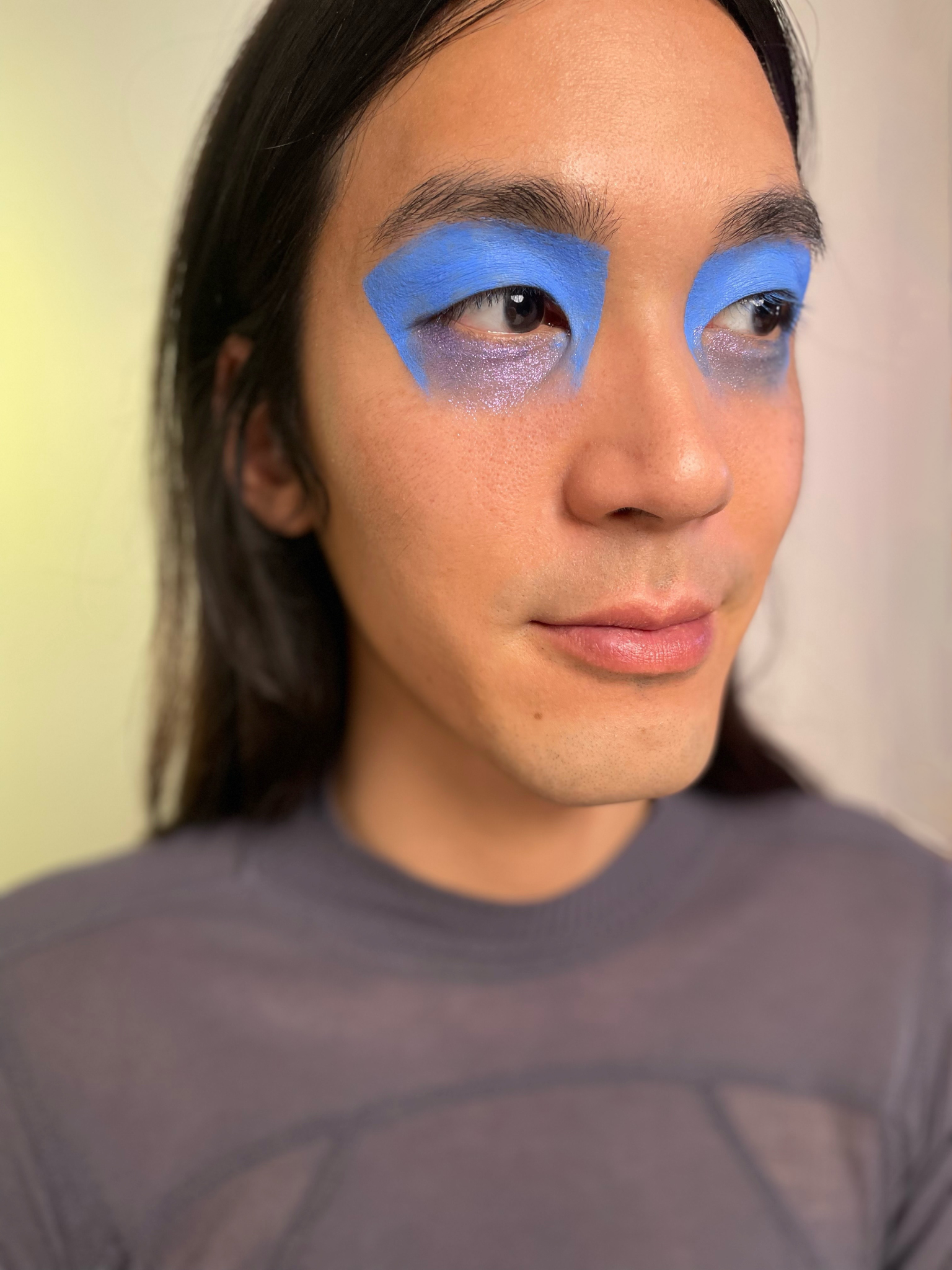 Model with medium skin tone with eye makeup applied with humanoid tape