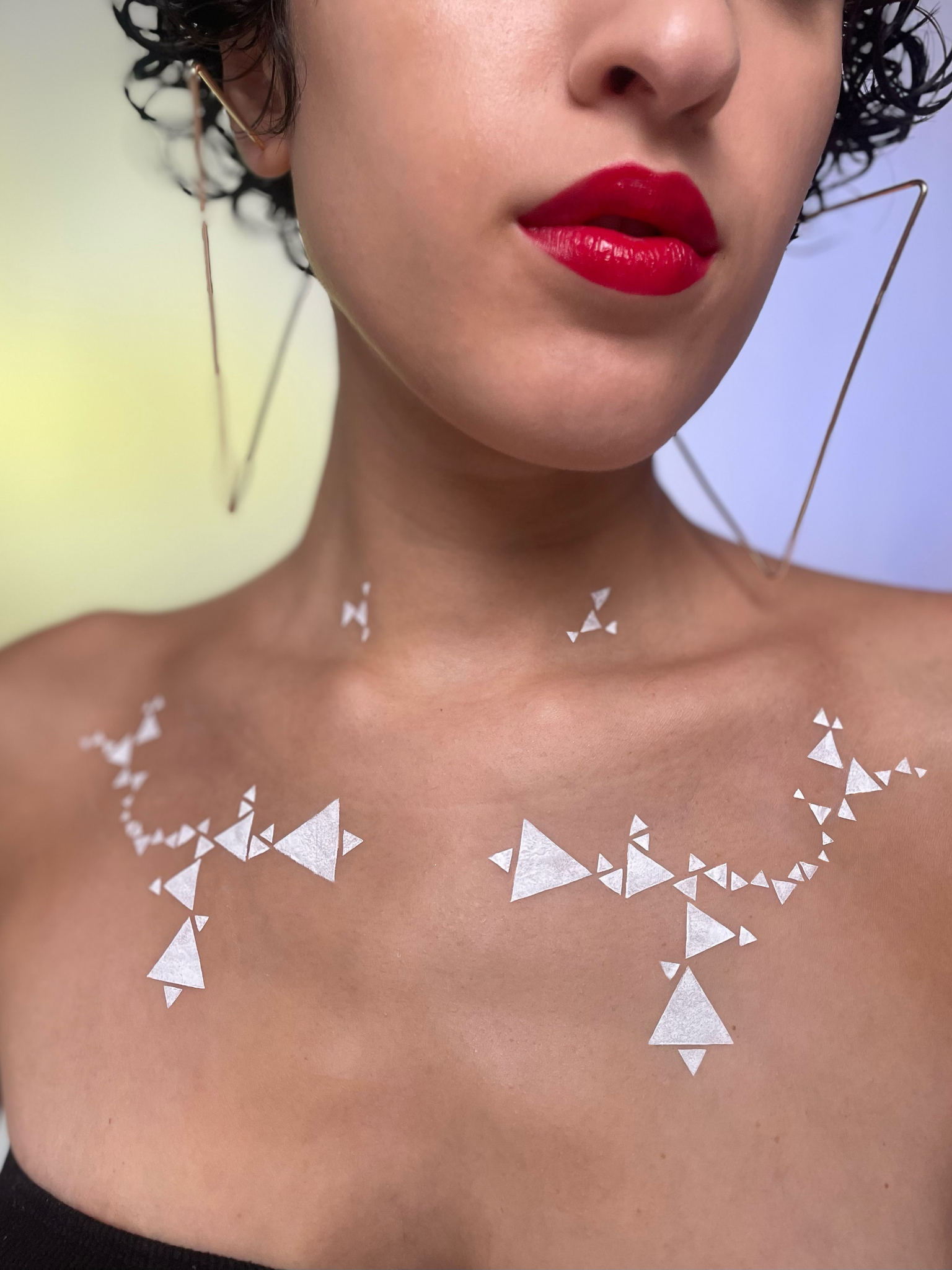 Model with a medium skin tone showcasing deepdive colorpot in Matilija with a geometric triangle pattern across their chest.