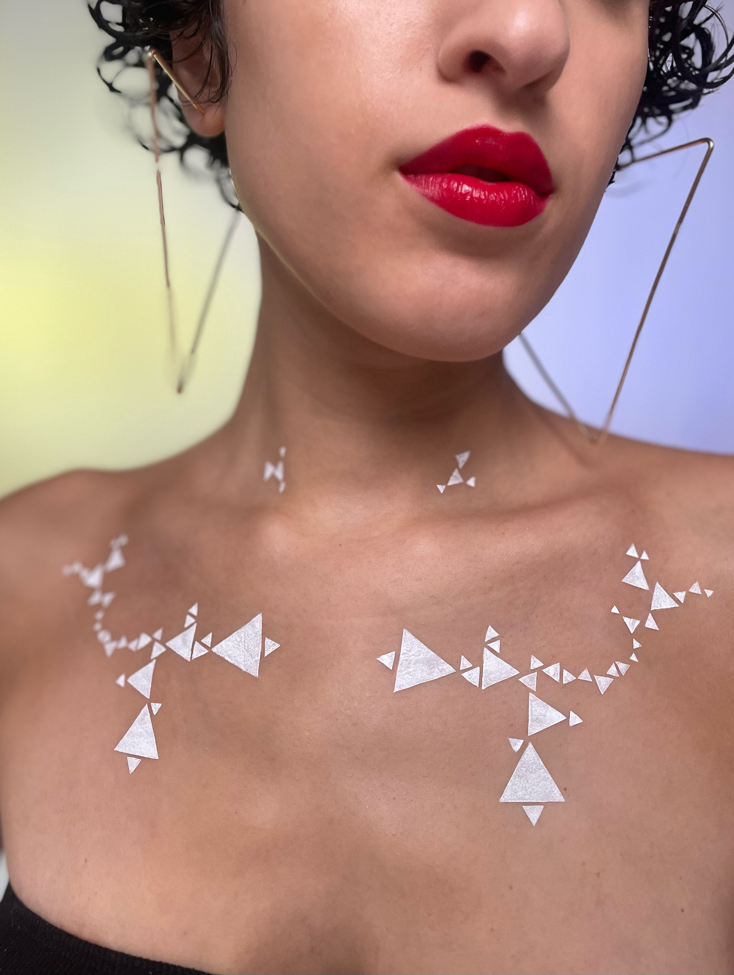 Model with medium skin tone showcasing deepdive colorpot in Matilija with geometric triangle pattern across their chest.