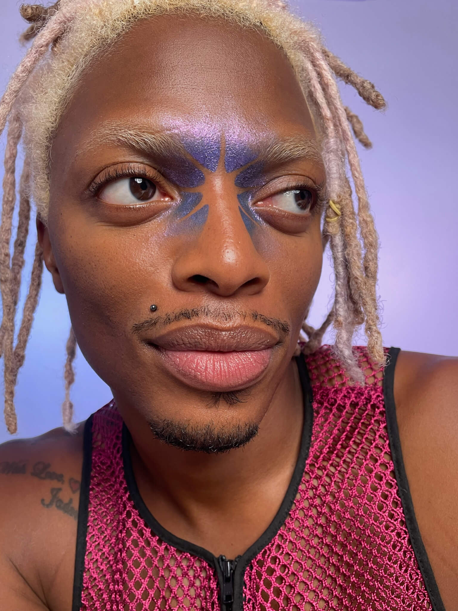 Model with dark skin tone wearing a humanoid skinwear along their inner eyes and brows