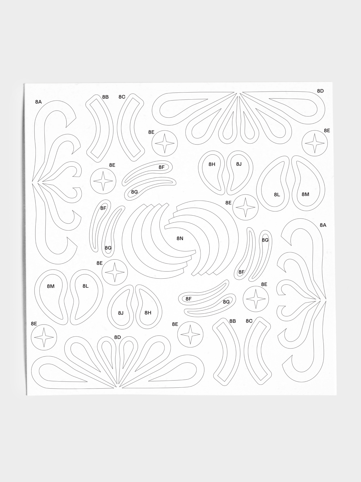 Closeup of stencil sheet with various teardrop and curved shapes.