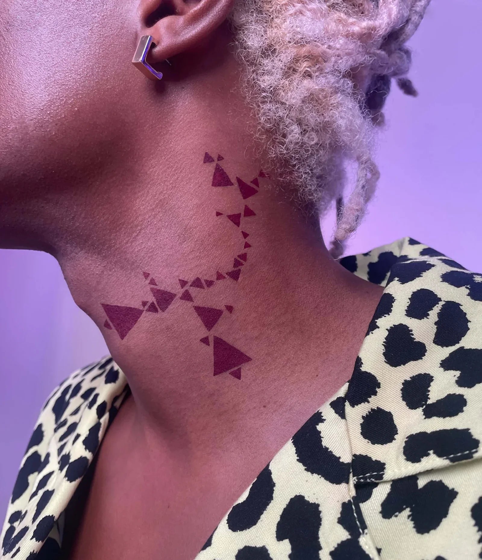 var:aeonium | matte red pigment in geometric pattern applied along neck using humanoid stencils