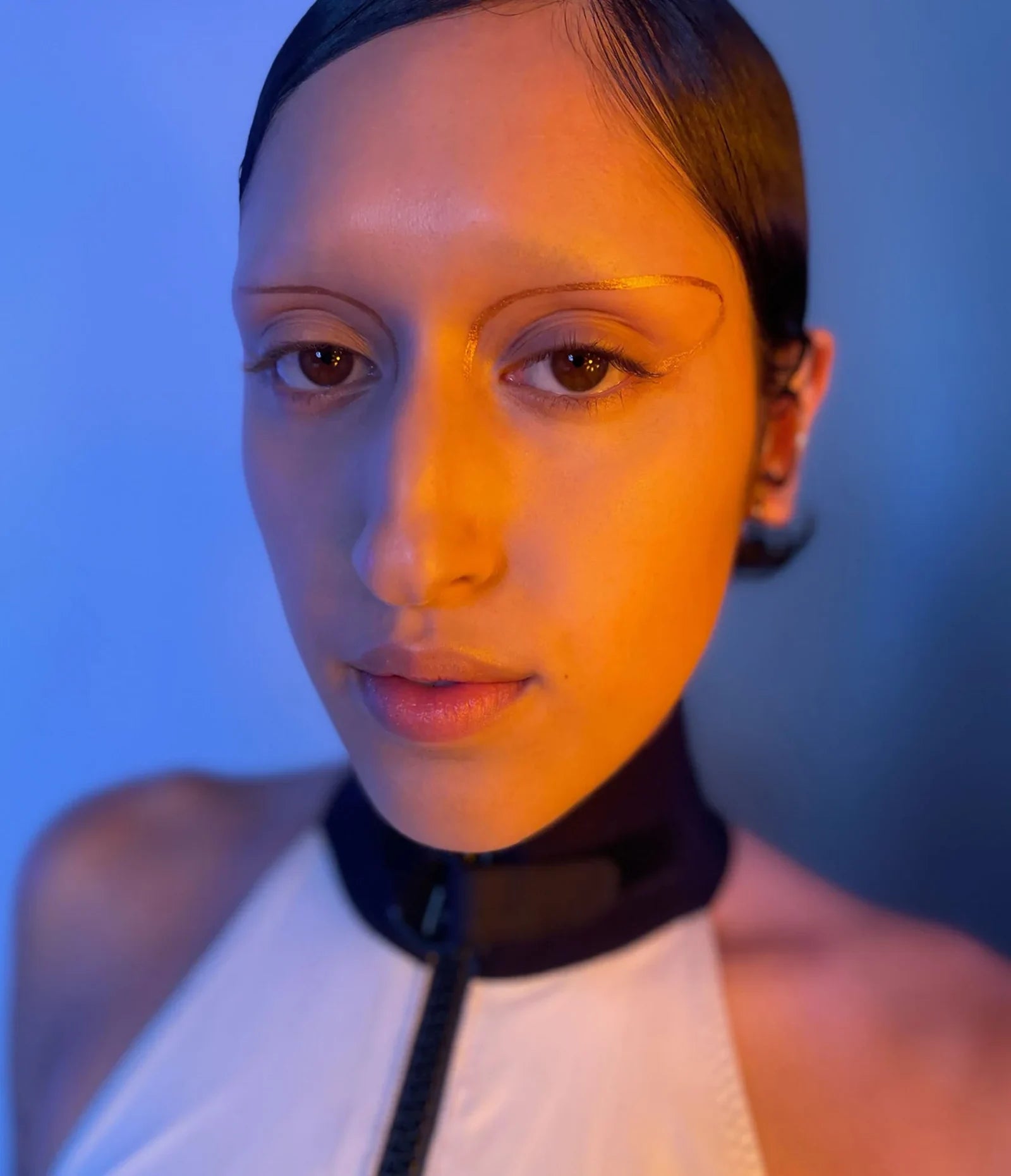 var:eventide | model wearing humanoid eventide deepdive pigment as bronze metallic eyebrow replacement arcs with sunset crimson shimmer